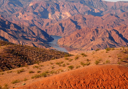 [Same scene as the prior image but with a yellow-orange cast to all the rocks, ground, and water.]